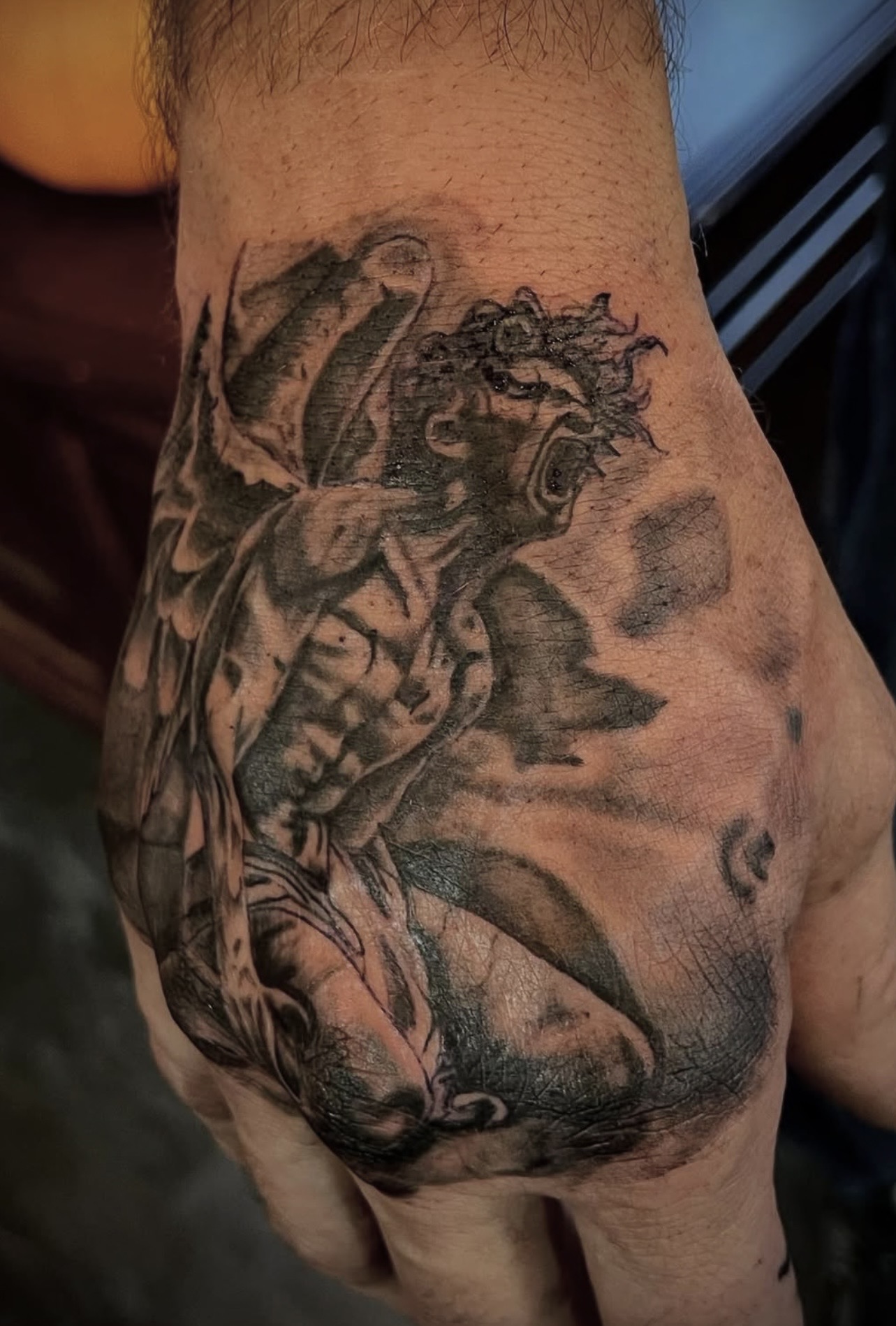 Black and grey fallen angel hand tattoo